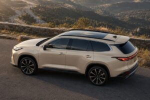 Elevated side-angle view of 2027 Toyota Highlander EV inspired electric SUV showing aerodynamic roofline and panoramic glasshouse