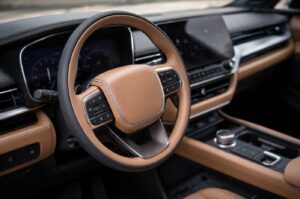 Close-up of 2027 Toyota Highlander EV inspired SUV steering wheel and physical interior controls