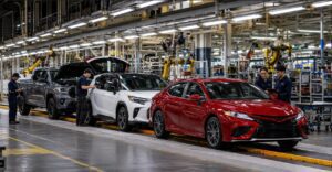 Toyota manufacturing in the USA with a modern vehicle assembly plant and workers inspecting Toyota-inspired vehicles